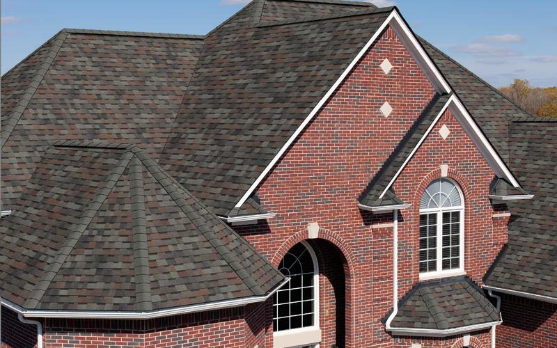 Brick home with a new dark hip roof