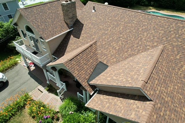Aerial view of a brown shingle roof with a turret