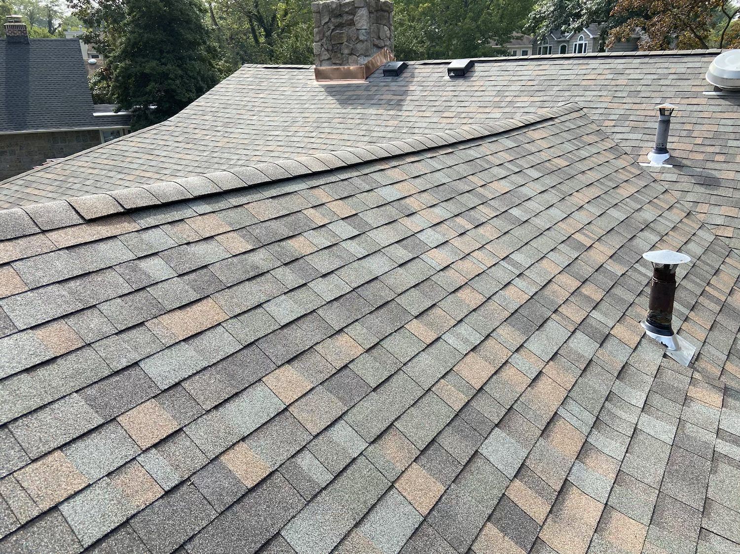 New gray shingles around a brick chimney