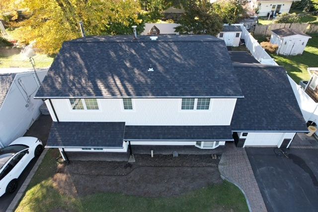 Aerial view of a dark roof on a large white colonial