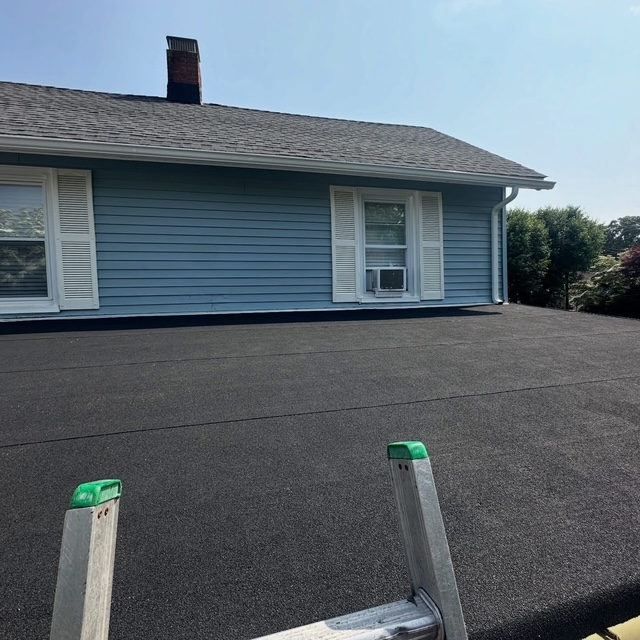 New flat roof section beside a blue house