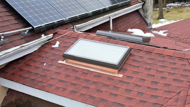 Skylight installed on a red shingle roof