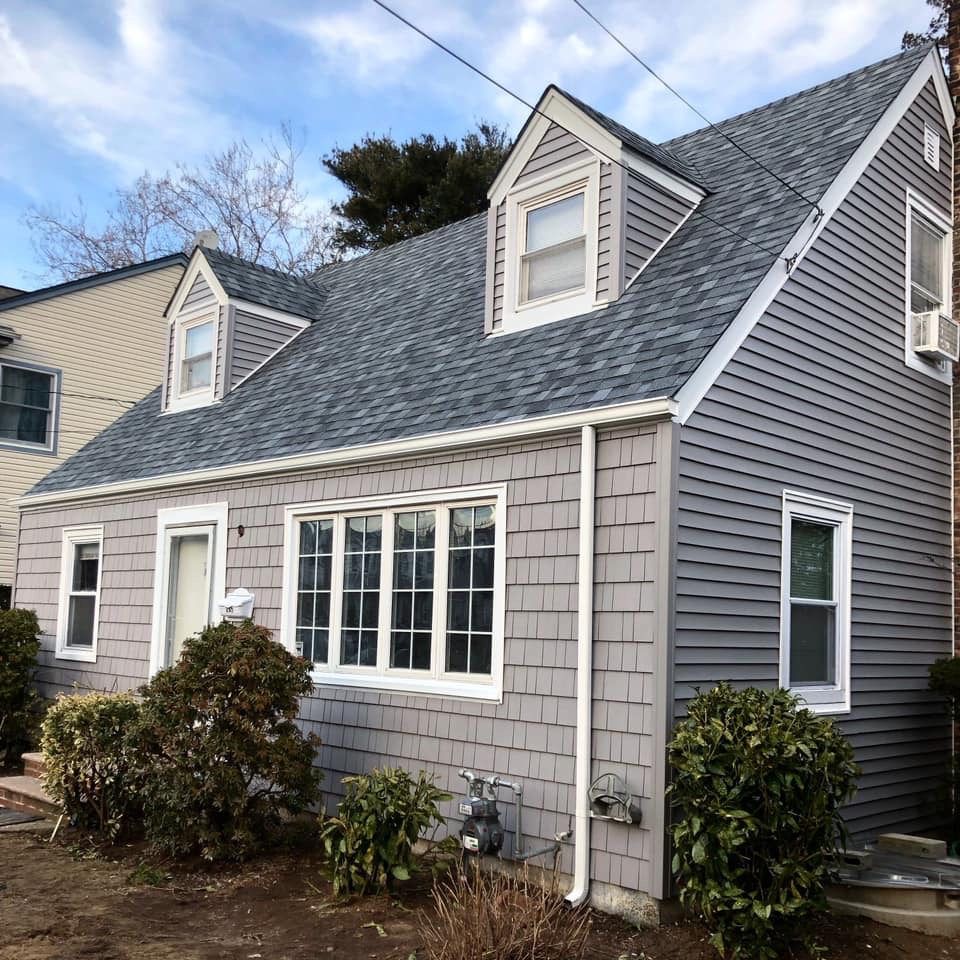 Cape house with new siding and a gray roof
