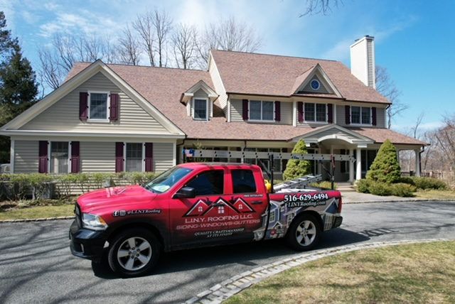 L.I.N.Y. Roofing's red pickup truck at a job