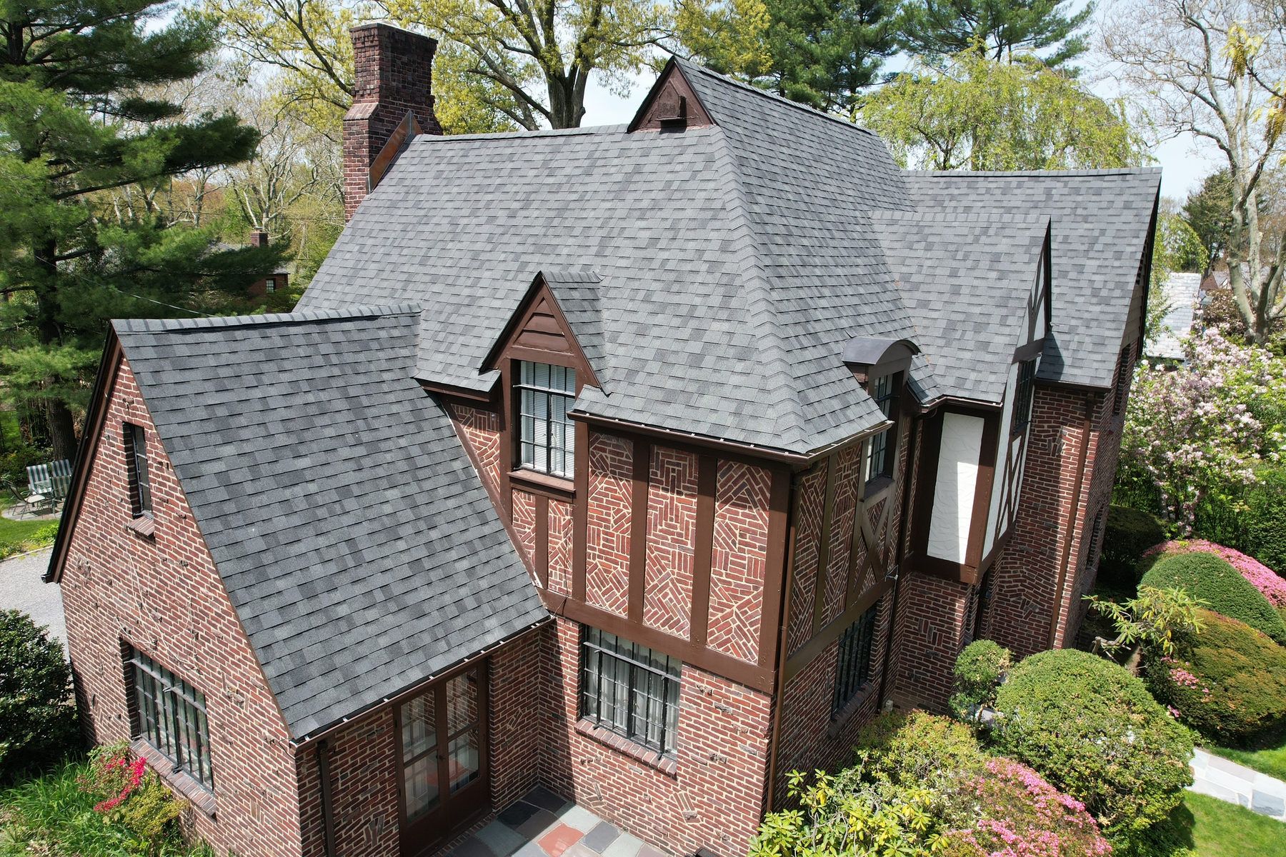 Tudor-style brick home with a new gray shingle roof